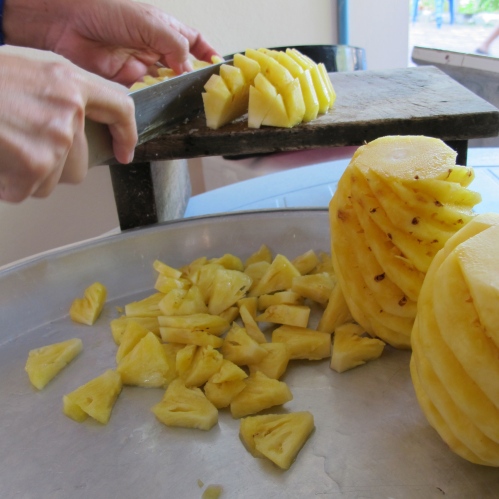 Cutting a half of Pineapple into wedges