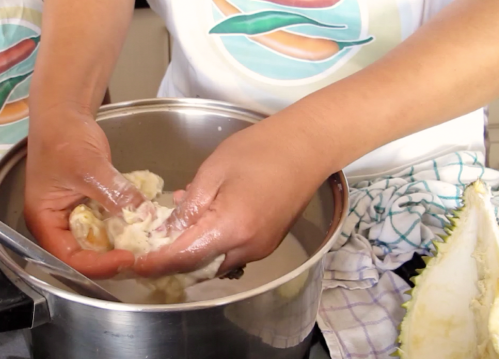 remove and discard seed from durian flesh by hand